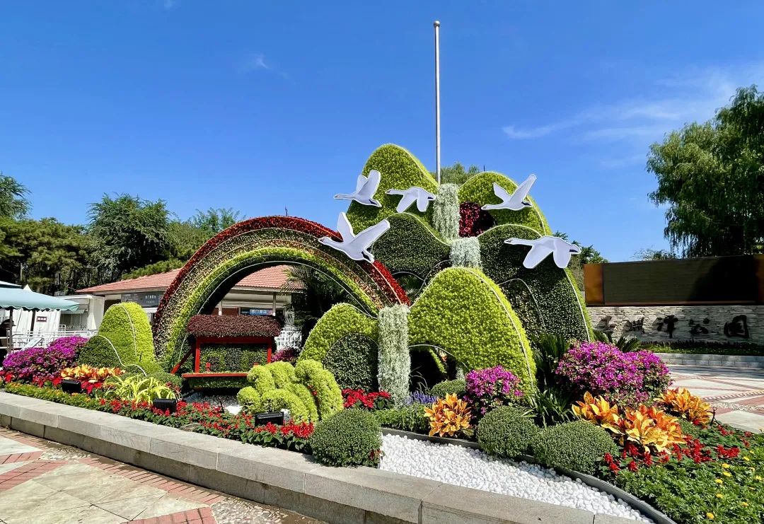 玉淵潭公園花壇中立體微縮“紅船”景觀行駛在蜿蜒的河流中。