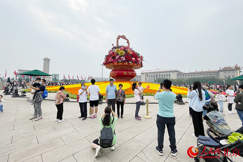 游客在“祝福祖國”巨型花果籃前合影留念。人民網(wǎng) 尹星云攝