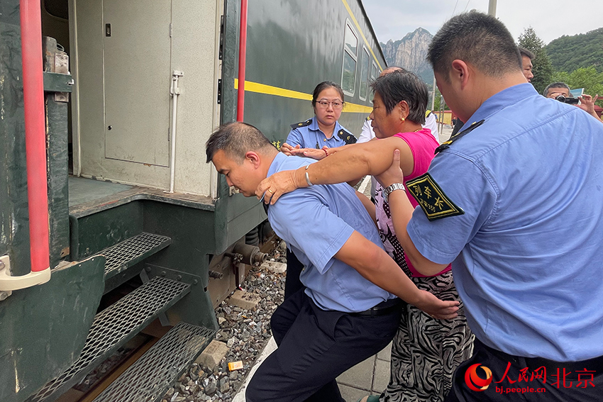 列車員幫助行動(dòng)不便群眾上車。人民網(wǎng)記者 尹星云攝