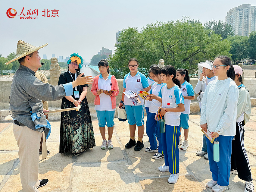 工作人員在向?qū)W生們講解永通橋（八里橋）的歷史文化。人民網(wǎng) 李世奇攝